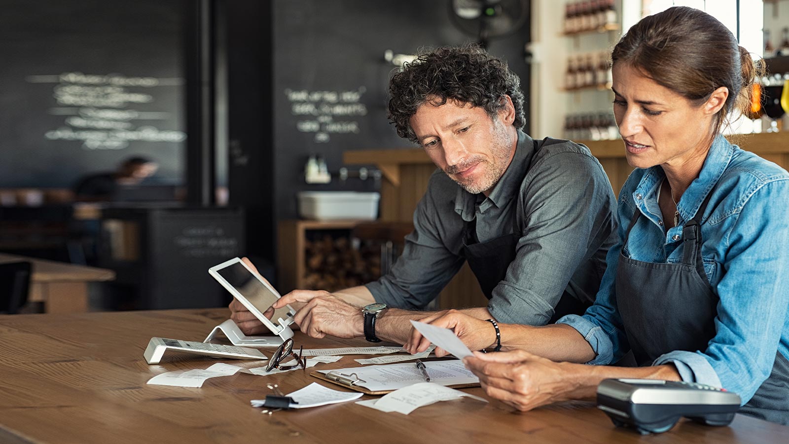 hombre y mujer revisando facturas de trabajo