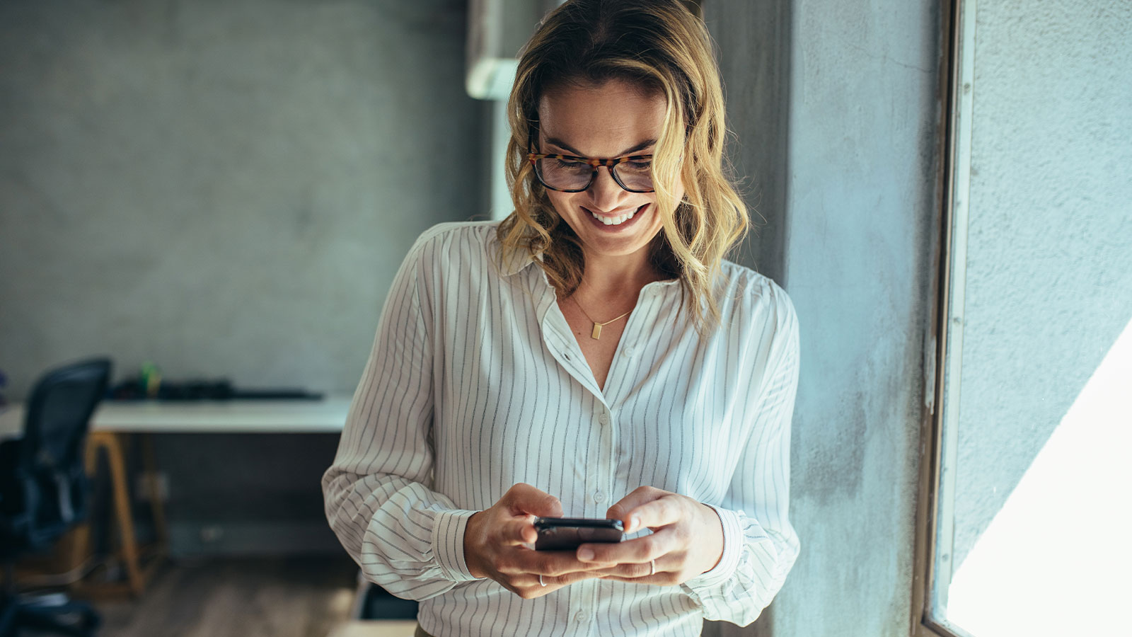 Mujer sonriente utilizando su celular