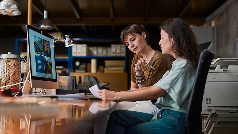 Mujeres conversando sobre trabajo en una oficina informal